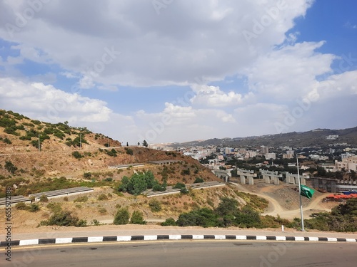 Beautiful daytime sky view of Al Bahah city in Saudi Arabia. City buildings, hills and clouds are visible in the background. photo