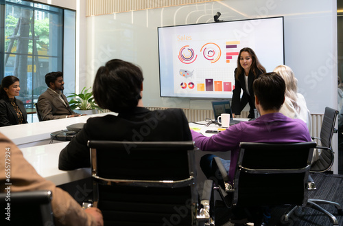 Businesswoman giving presentation to a group of people in a conference room