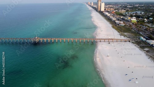 Aerial view of Fishing pier on the beach. Early morning view of beach with volleyball net on the beach. Aerial footage of Panama city beach in Florida USA photo