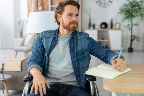 disabled young man at home writing on notebook