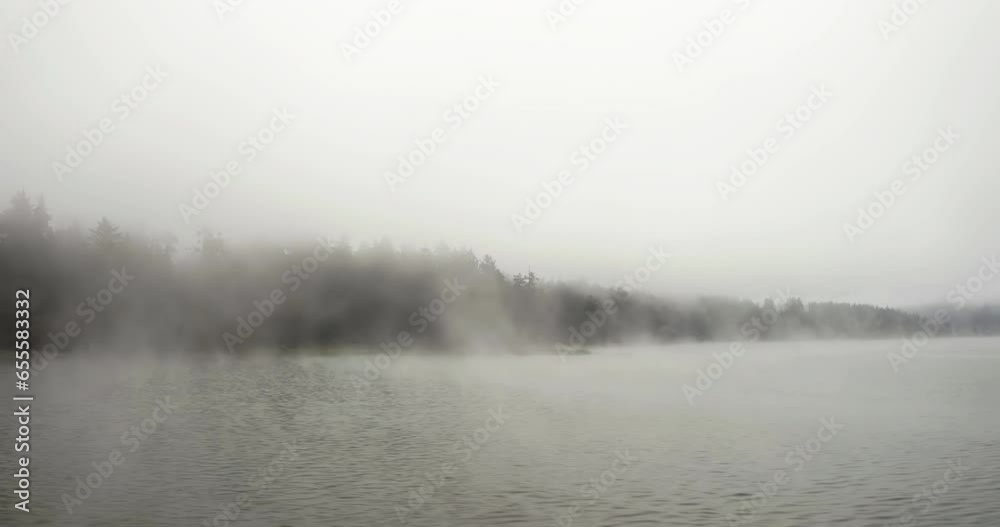 Aerial tracking shot low over water surface on a misty lake, cloudy day in USA Aerial tracking shot low over water surface on a misty lake, cloudy day in USA
