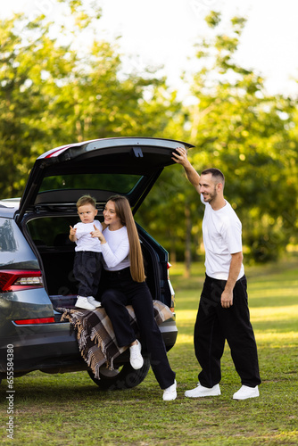 Happy young family sitting in the car outdoors