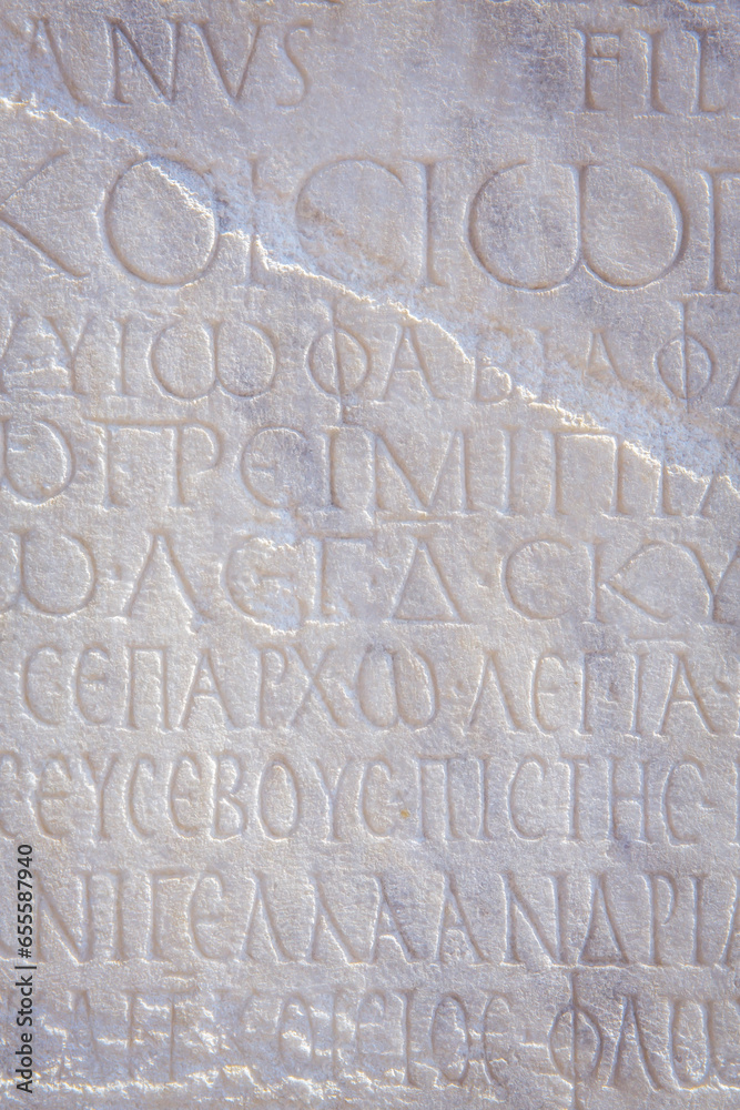 Historical inscription. Fragment of ancient law (imperial edict at Ancient Greek language), carved on marble block. Retro grunge background, film stylization, vertical. Kayseri, Turkey (Turkiye)