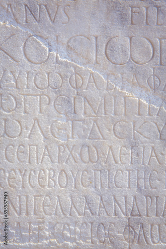 Historical inscription. Fragment of ancient law (imperial edict at Ancient Greek language), carved on marble block. Retro grunge background, film stylization, vertical. Kayseri, Turkey (Turkiye)