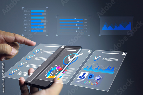 Businessman using smart phone to tick check mark on data analytic screen information approve management e-document paperless evaluating supplier industrial facility documentation management system.