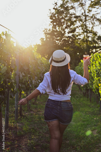 Young beautiful Smiling  italian woman walking at wineyard with a Glass of Red wine.Wine tourism at Tuscany,Italy © Striker777