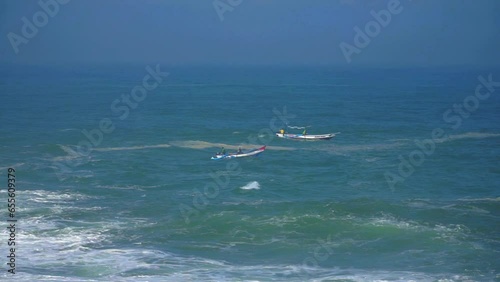 Small fisherman boats swinging on ocean waves in Indonesia, aerial view photo
