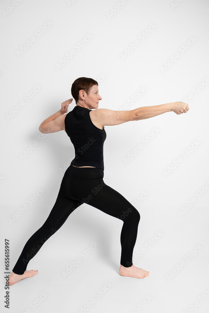 Paris, France - 09 30 2023: Athletic mature woman dressed in black, miming the sporty gesture of fencing.