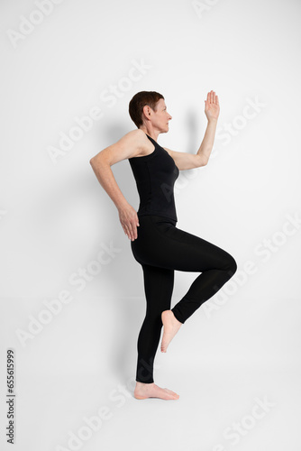 Paris, France - 09 30 2023: Athletic mature woman dressed in black, miming the sporty gesture of running..