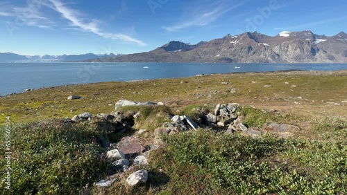 Static camera view at historical remains of Thule-culture winter houses on Denmark Island, Scoresbysund, Greenland.