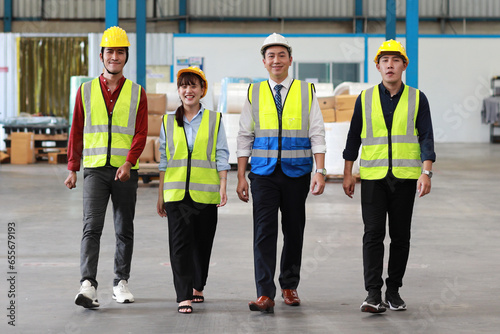 Group of technician engineer and businessman in protective uniform with hardhat walking together at industry manufacturing factory