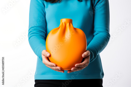 Individual holding a hot water bottle for autumn illness warmth isolated on a white background