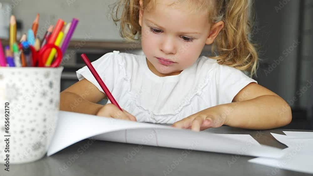 Little girl draws with colored pencils in home. Little girl draws with colored pencils in home.