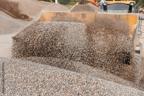 Yellow Excavator loading sand to industrial truck on industry quarry. Construction site open pit mine concept