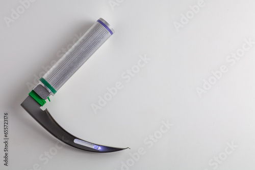 There is a laryngoscope on a white table. Copy space. photo