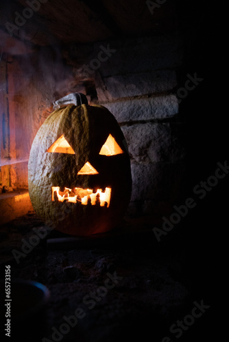 scary Halloween pumpkin glowing in window at night