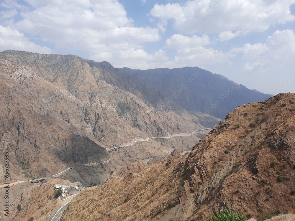 A beautiful view of the mountain road of Al Bahah, Saudi Arabia during the day. This road goes up high between high mountains.