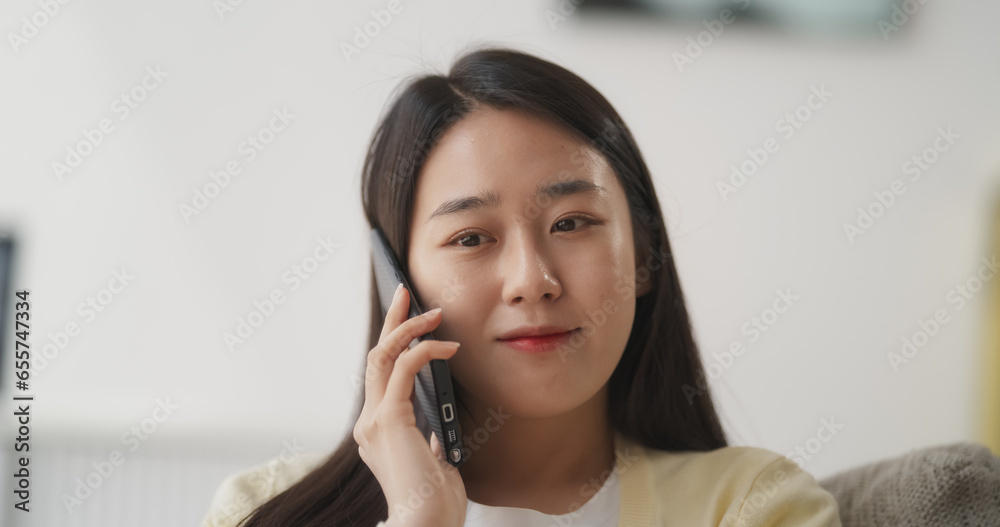 Portrait of an Engaged Young South Korean Female Having an Inspiring Phone Call, She Finds Comfort on the Sofa in Her Cozy Living Room, Having a Positive Discussion with a Friend or Family Portrait of an Engaged Young South Korean Female Having an Inspiring Phone Call, She Finds Comfort on the Sofa in Her Cozy Living Room, Having a Positive Discussion with a Friend or Family