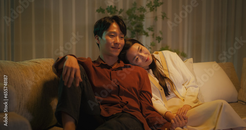 Fotografi Portrait of a South Korean Couple Watching Romantic Comedy Movie on TV