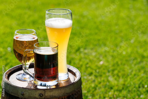 Bilde på lerret Variety of beer glasses on rustic wooden barrel