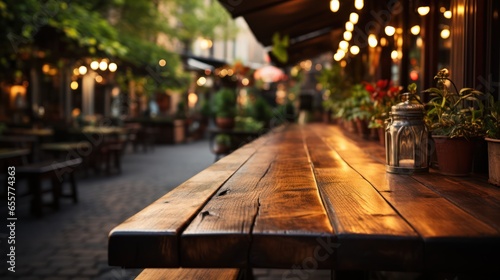 Empty wooden table in front of abstract blurred background of street cafe.