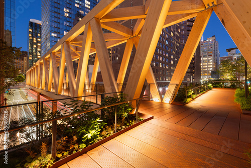 High Line public park with a timber wooden truss bridge in evening. Chelsea, Manhattan, New York City