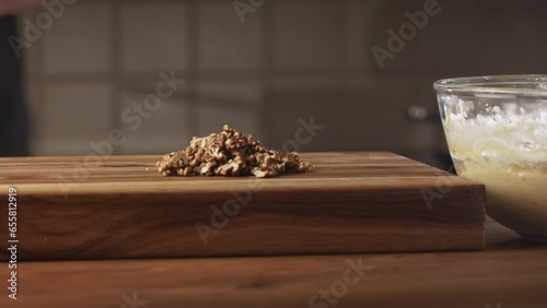 Closeup shot of a man making banana bread at home. Home cooking and baking concept. Chopping walnuts.
