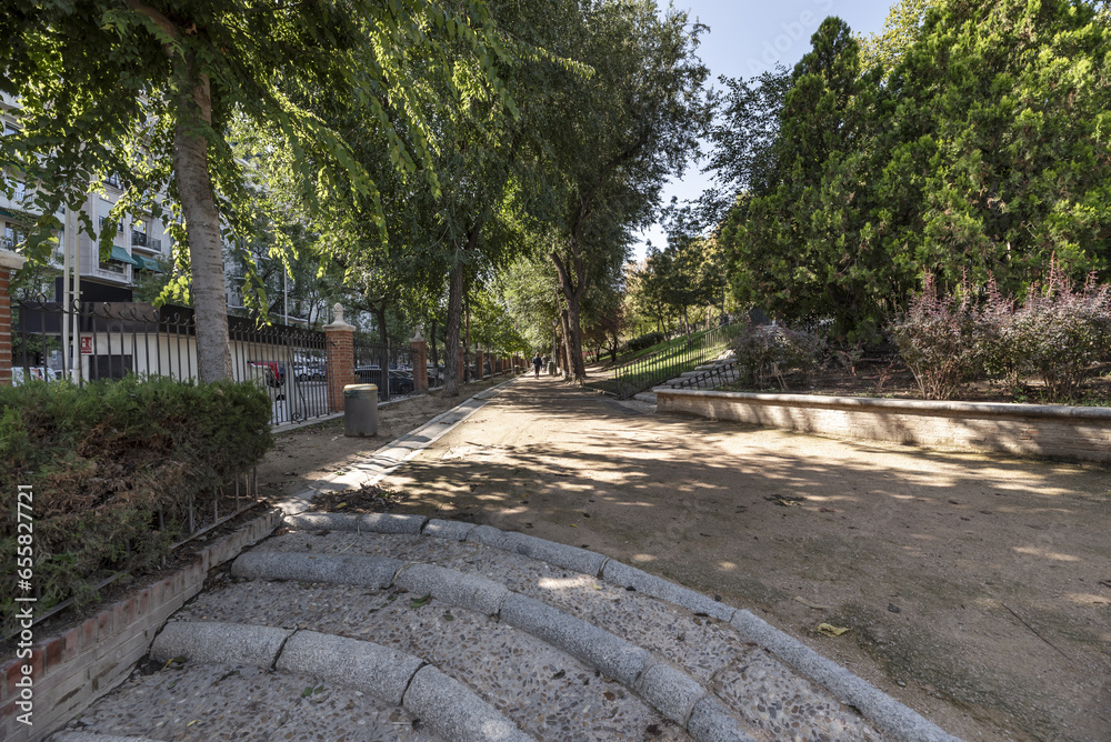 Long sandy walk with granite and stone stairs in an urban park with plenty of trees