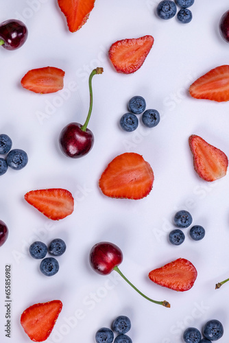 background of blueberries, strawberries, lemon, orange, grapefruit and kiwi slices on a white background - the concept of a healthy diet. Summer bright food fruit background, food design