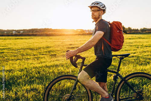 Male caucasian cyclist standing with his bike. Young pretty athletic man with bicycle outdoor. Active sporty people concept image