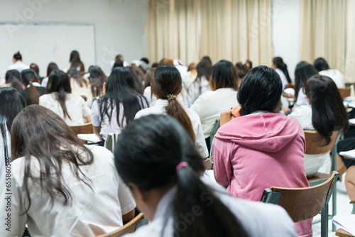 Asian college students concentrate on doing examinations in the classroom. Education stock photo