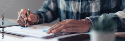 Businessman taking notes while checking about financial and accounting report of business project