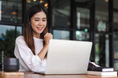 Businesswomen use laptop to meeting in video call and taking notes while working in outside office