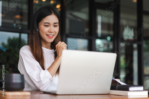 Businesswomen use laptop to meeting in video call and taking notes while working in outside office © snowing12