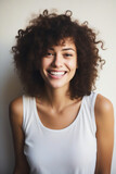 Woman with smile on her face and white tank top.