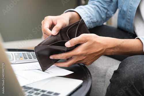 Bankruptcy problem financial concept, Young man opening empty wallet stress to find money to pay debt mortgage  period.