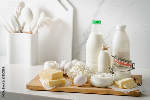 Fresh dairy products, milk, cottage cheese, eggs, yogurt, sour cream and butter on kitchen table