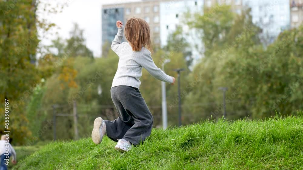 Child girl playing at playground. Cute girl running through green grass Child girl playing at playground. Cute girl running through green grass