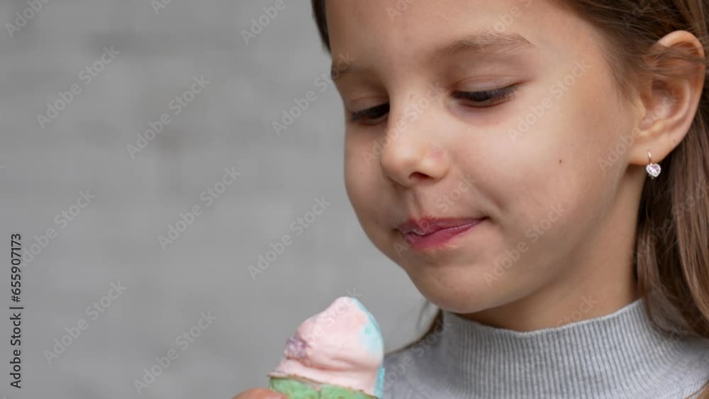 Child with ice cream on grey background, close-up