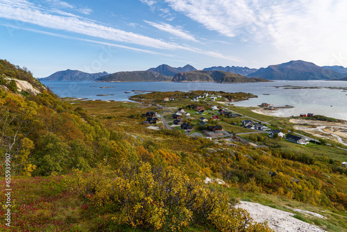 wonderful panoramic view from Nordkollen mountain down to Sommarøy and Kvaløya. Pano with the village and the harbor facilities and wind turbines in the background and great autumnal red-colored plant