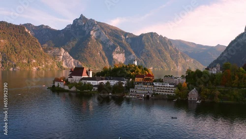 4k drone flight moving to the side footage (Ultra High Definition) of Maria Kronung church. Colorful autumn scene of Traunsee lake in Austrian Alps with Traunstein peak on background, Austria, Europe. photo