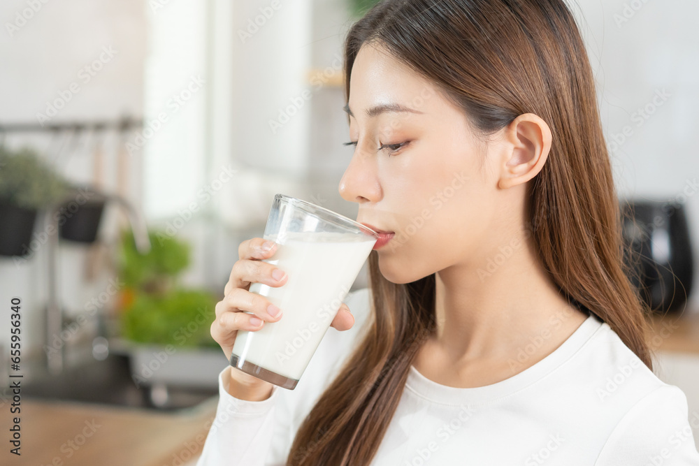Health care, pretty asian young woman, girl drinking a glass of white fresh, dairy milk for calcium, vitamin wholesome good nutrition in morning at kitchen home. lifestyle, product healthy people. Health care, pretty asian young woman, girl drinking a glass of white fresh, dairy milk for calcium, vitamin wholesome good nutrition in morning at kitchen home. lifestyle, product healthy people.