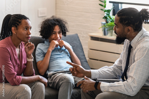 African American woman with teen son have a meeting with a psychologist. A psychotherapist session with a patient. mother seeks professional help for her teenage son