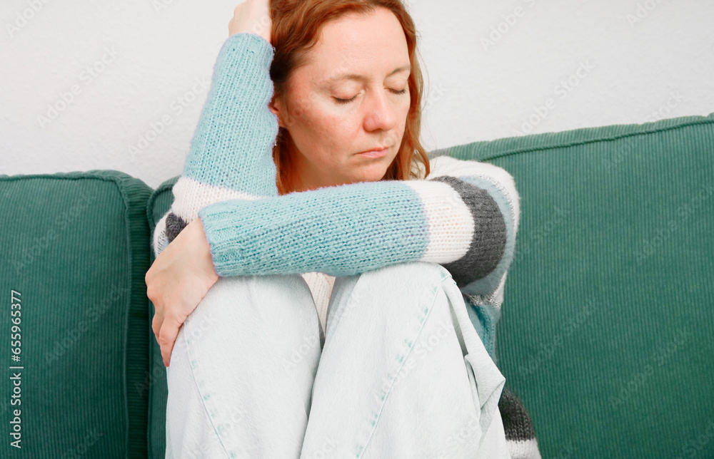 Depression. Woman sitting alone on sofa in depressed mood