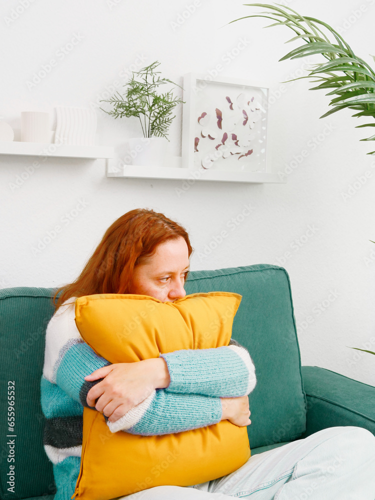 Depression. Woman sitting alone on sofa in depressed mood