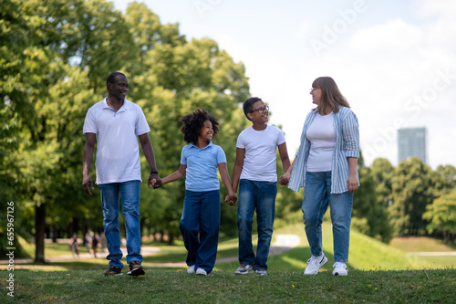 Interracial family in the park together looking happy