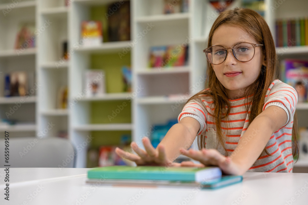 Girl in eyeglasses sitting at the desk at school Girl in eyeglasses sitting at the desk at school