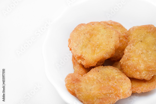 Chicken nuggets on a white plate. Fried chicken meat in pieces.