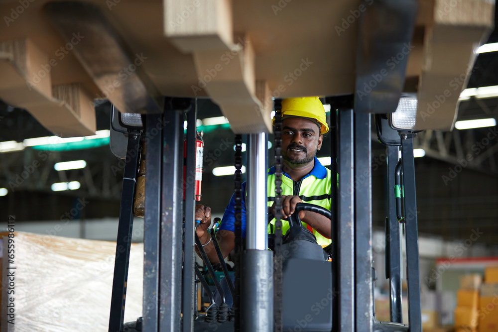 worker driving a forklift and pick up a pallet in the warehouse storage ...