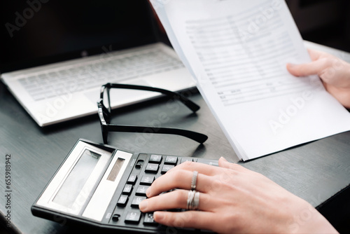 Professional Businesswoman Analyzing Financial Budget and Conducting Accounting in Office, Accountant Calculating Finance Report with Calculator, Detailed Financial Analysis and Budgeting in Progress